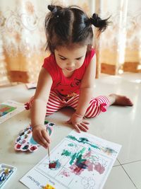 Cute girl holding paper at home