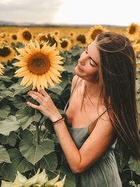 Midsection of woman by sunflower