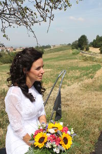 Young woman holding flower on field