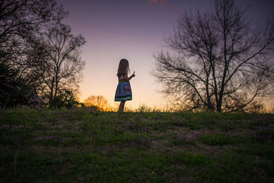 Little girl holding flower silohette long hair summer evening sunset