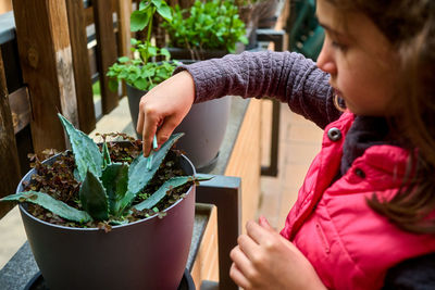 Cute girl sitting by plant