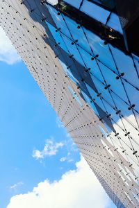 Low angle view of modern building against cloudy sky