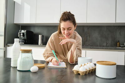 Portrait of young woman drinking coffee at home