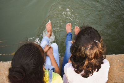 Rear view of friends against water