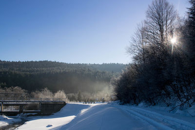 Snow covered landscape against clear sky