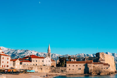 Buildings in town against blue sky