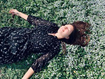 High angle view of woman lying on meadow at garden