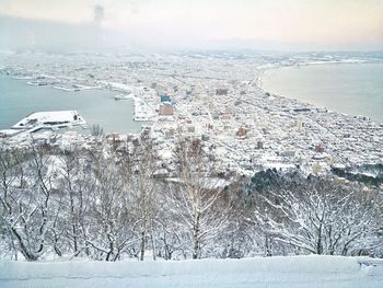 Aerial view of city by sea during winter