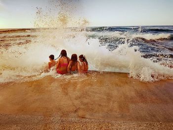 People at beach against sky