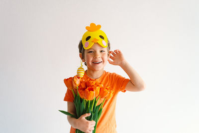 Portrait of boy with flowers against white background