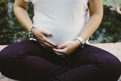 Midsection of woman with arms raised