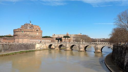 Arch bridge over water against blue sky