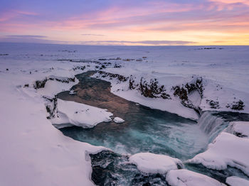 Scenic view of snow covered landscape against sky during sunset