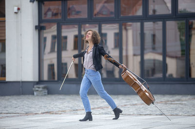 Full length of woman with violin on street