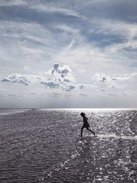 Man jumping in sea against sky