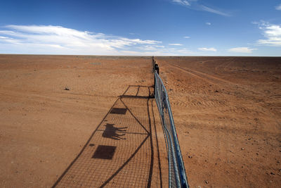 High angle view of fence at desert against sky