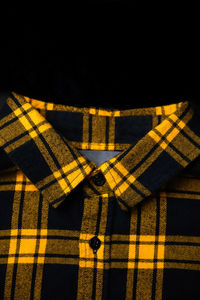 Black and yellow checkered shirt. gingham tablecloth back pattern. fragment of a wrinkled squared 