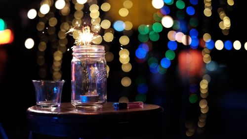 Close-up of illuminated tea light candles on table