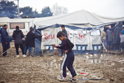 People standing by tent on field