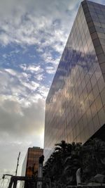 Low angle view of modern building against cloudy sky