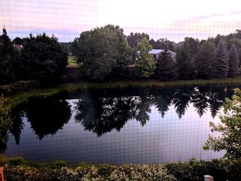 Reflection of trees in lake against sky