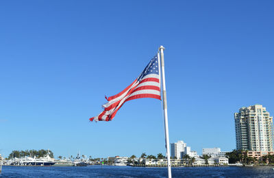 American flag flying in the background of fort lauderdale canals and on a sunny summer day.