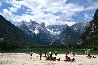 People on snowcapped mountains against sky