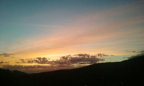 Scenic view of mountains against sky at sunset