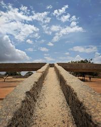 Rock aquaduct amidst field against sky