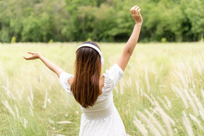 Rear view of woman standing on field