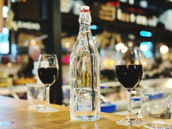 Close-up of wineglasses on table and water bottle 