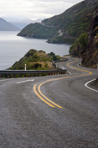 Road by sea against mountains