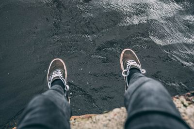 Low section of man on retaining wall against sea