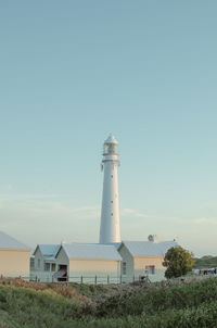 Lighthouse on field against sky