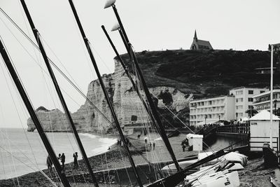 Sailboats in sea against buildings