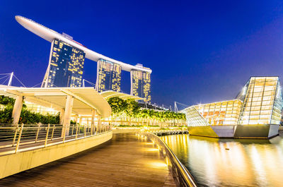 Illuminated building against blue sky at night