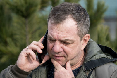 Close-up portrait of man holding cigarette outdoors