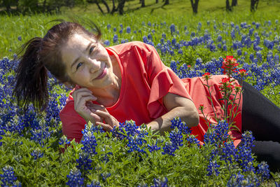 Midsection of woman by flowering plants on field