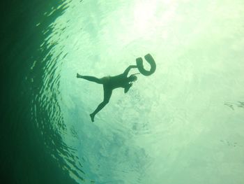 Silhouette person swimming in sea