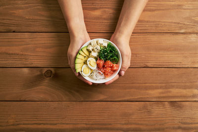 Directly above shot of woman holding food on table