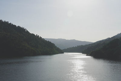 Scenic view of river and mountains against clear sky