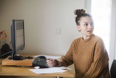 Young woman with bun talking in an office