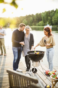 Friends enjoying barbecue party on pier