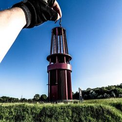 Low angle view of man working on field against clear sky