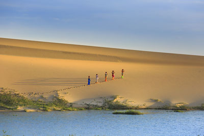 People at beach against sky