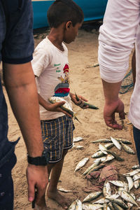 Rear view of people standing by fish