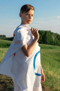 Side view of woman standing on field against sky