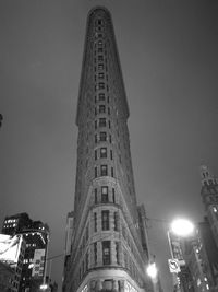 Low angle view of illuminated buildings against sky at night