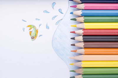 Close-up of multi colored pencils on white table