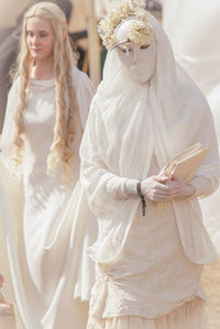Woman with arms wearing mask walking outdoors